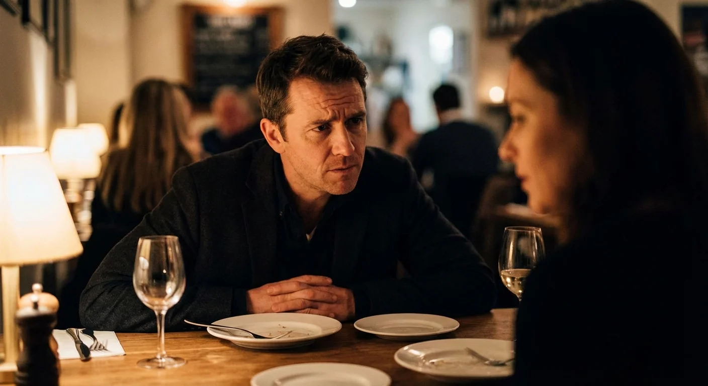 A man watching his partner's face closely during a meal, looking worried.