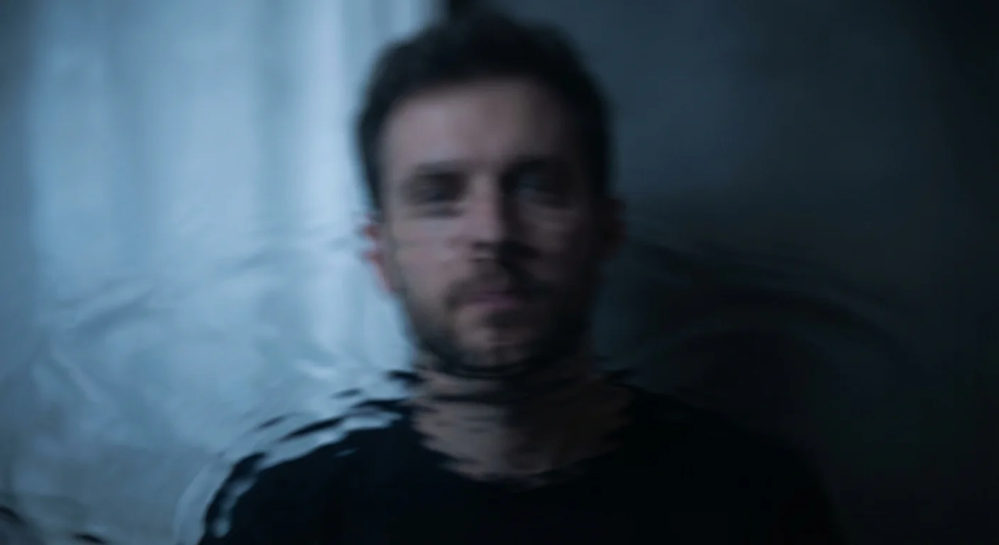 A man's distorted reflection in a pool of water, symbolizing internal confusion.